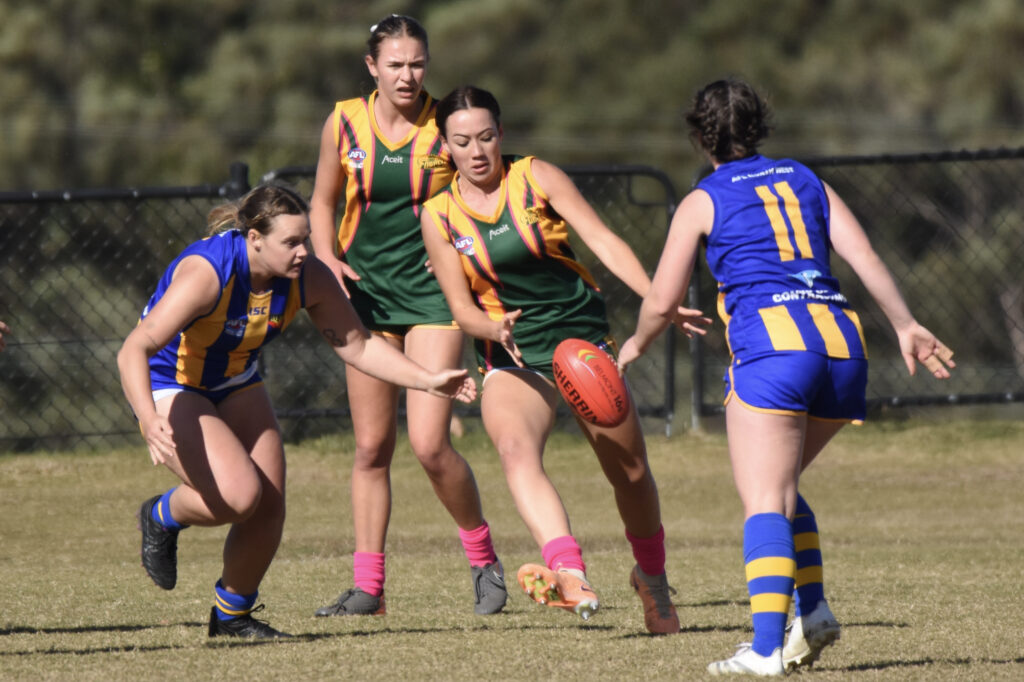 Sawtell/Toormina's Indi Loos gets a kick away for the North Coast Force despite the opposition attention from the North West Blue Heelers.