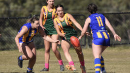 Sawtell/Toormina's Indi Loos gets a kick away for the North Coast Force despite the opposition attention from the North West Blue Heelers.